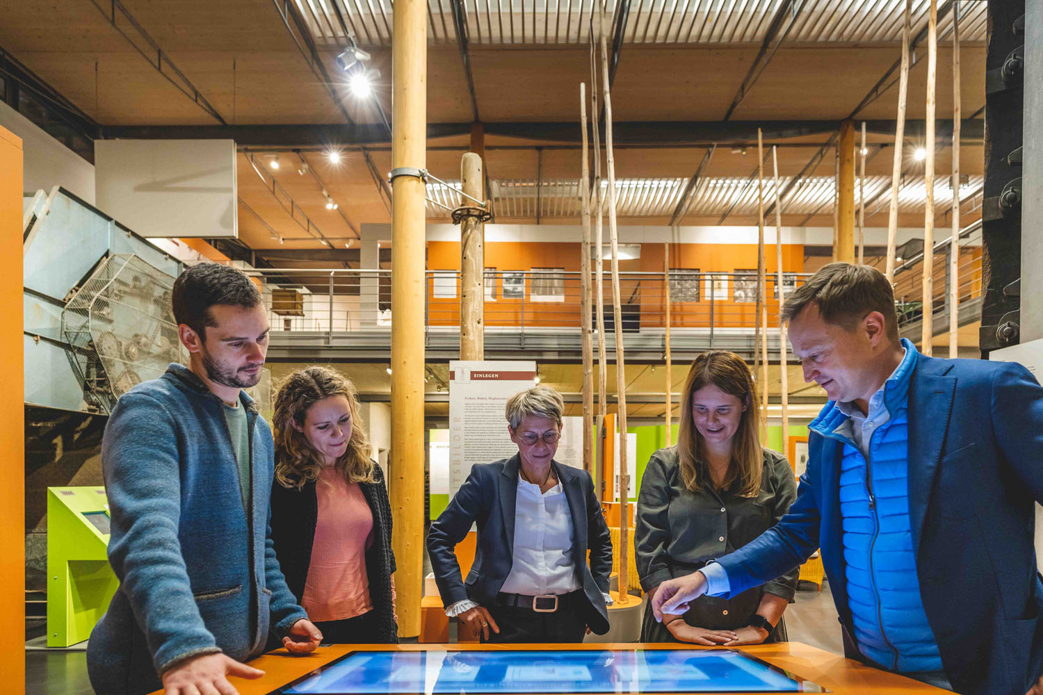 Visitors to a guided tour stand at a media station