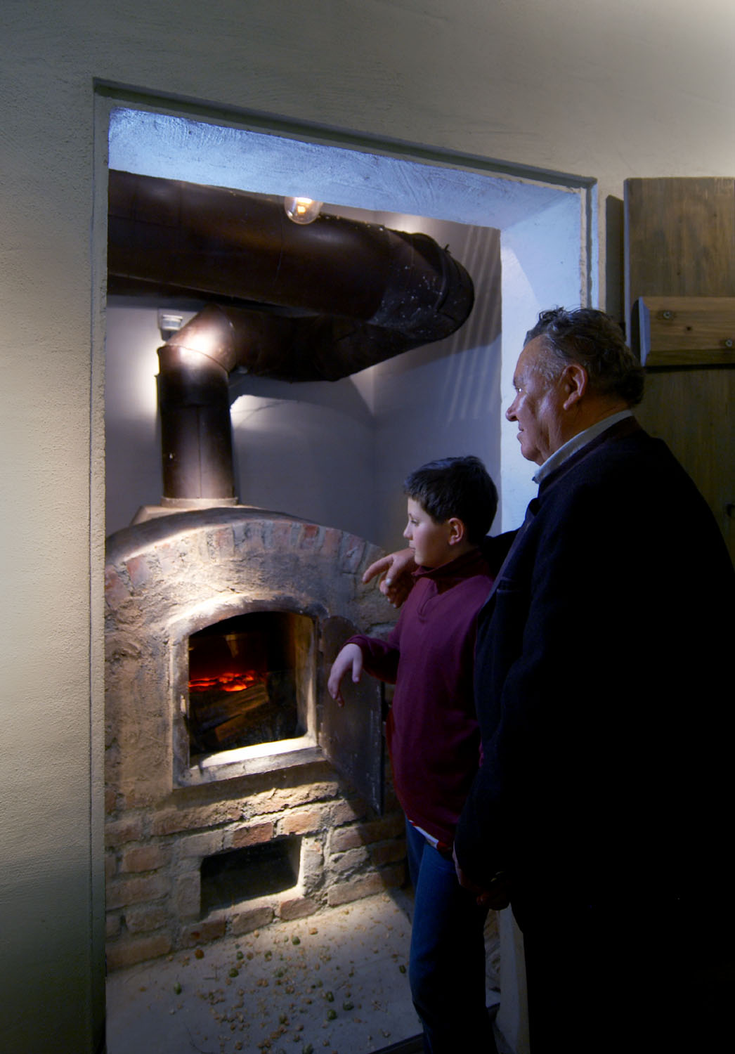A museum guide shows a boy the replica of a hop kiln