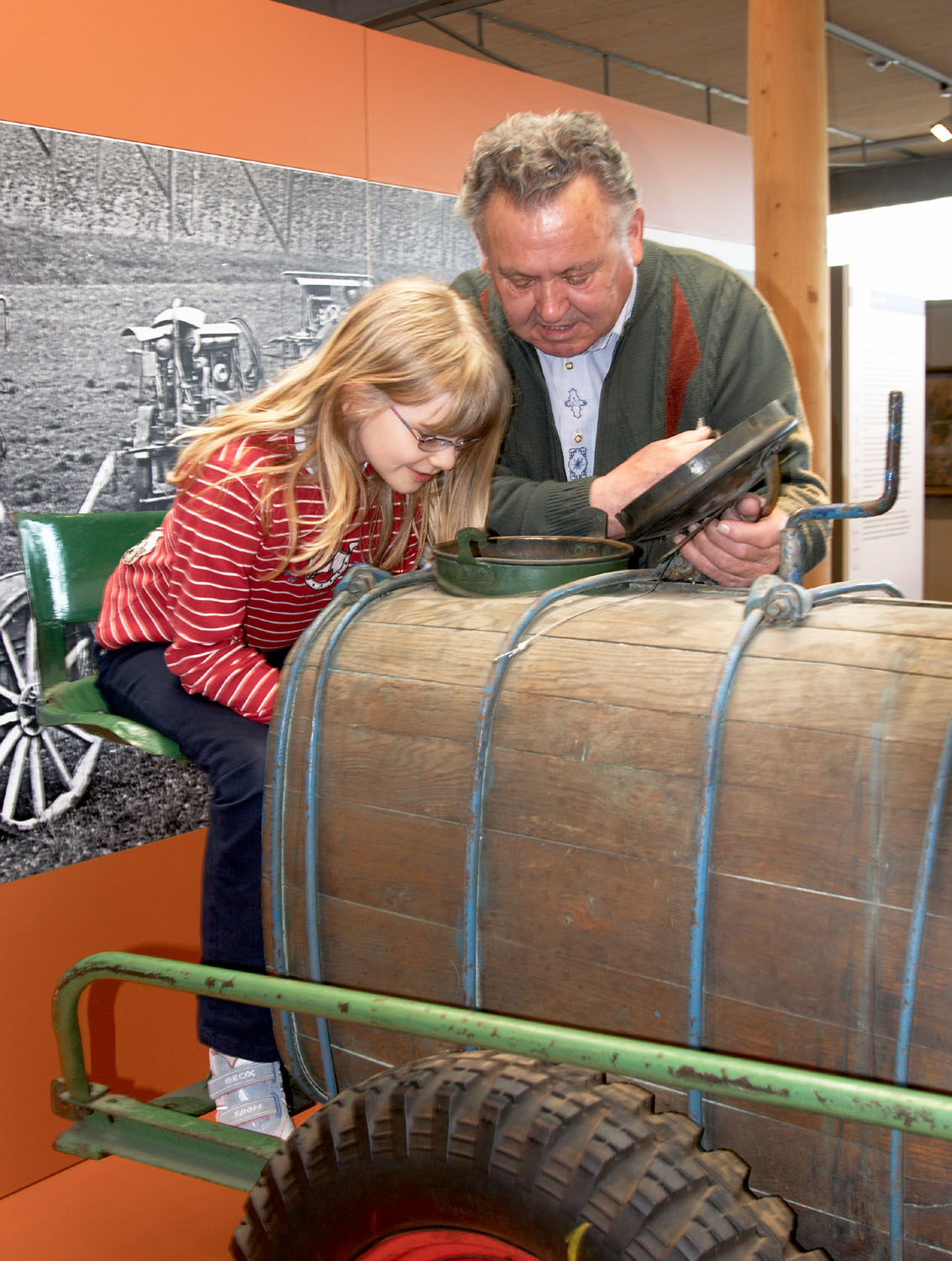 A museum guide shows a girl a machine