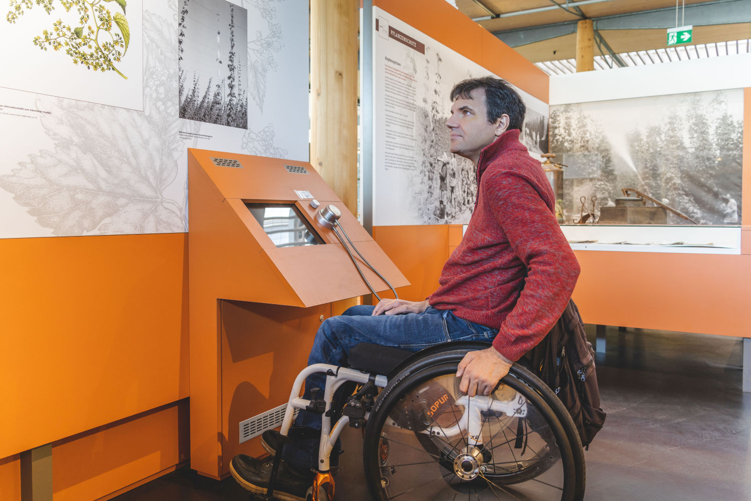 Rollstuhlfahrer an einer Medienstation im Deutschen Hopfenmuseum